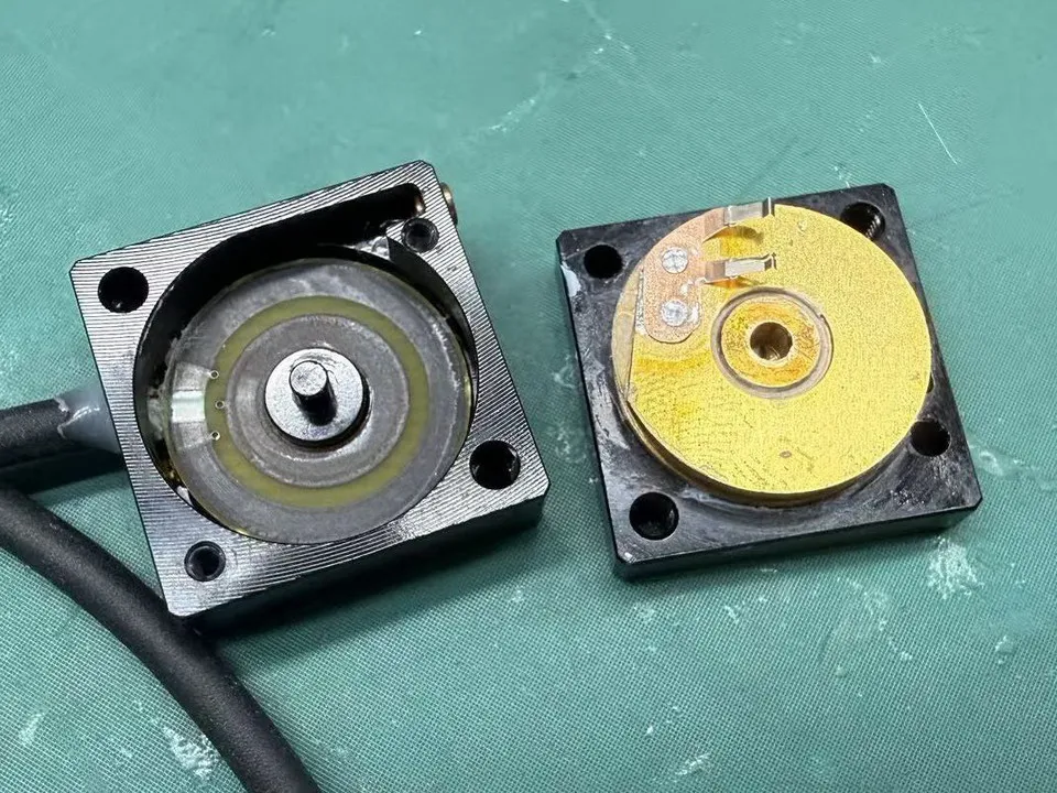 Disassembled string potentiometer showing the internal resistive track and wiper structure